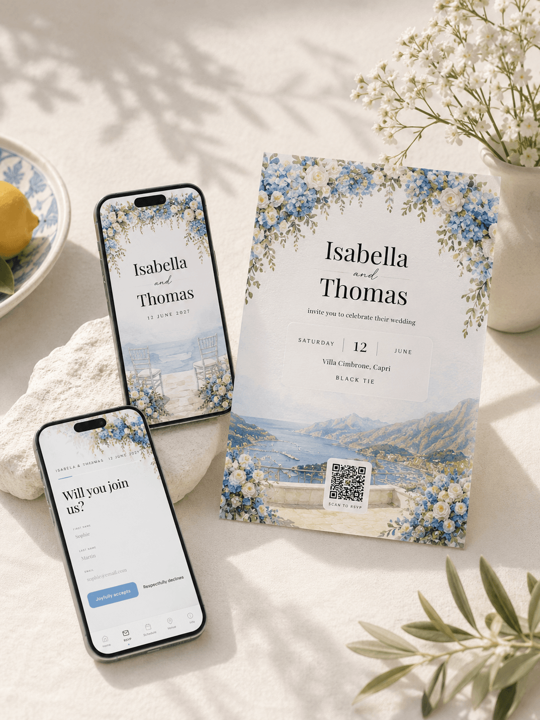 Faire-part de mariage aquarelle Art déco sur une table en pierre avec fleurs séchées et branches d'olivier : carte imprimée aux fleurs en relief avec les prénoms, la date, le lieu et un QR code à scanner pour confirmer sa présence, un téléphone montrant l'enveloppe scellée à la cire et un téléphone montrant la couverture du faire-part numérique avec compte à rebours