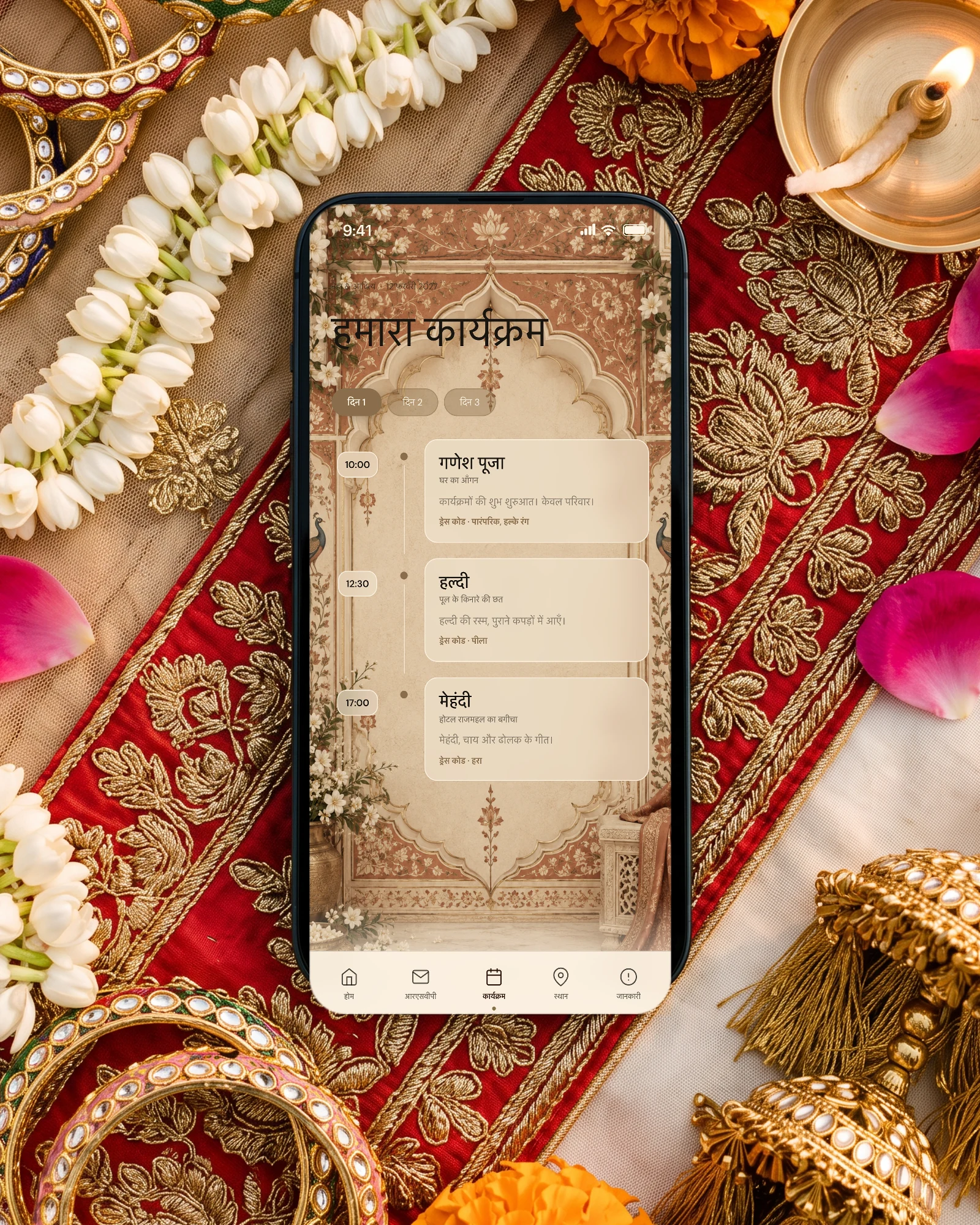 3 दिन की शादी का कार्यक्रम: लाल-सुनहरे लहंगे के दुपट्टे, कुंदन चूड़ियों और मोगरे की माला के बीच रखा फ़ोन, जिसमें “हमारा कार्यक्रम” पर दिन 1, दिन 2, दिन 3 के टैब और गणेश पूजा, हल्दी और मेहंदी का समय, जगह और ड्रेस कोड दिख रहा है