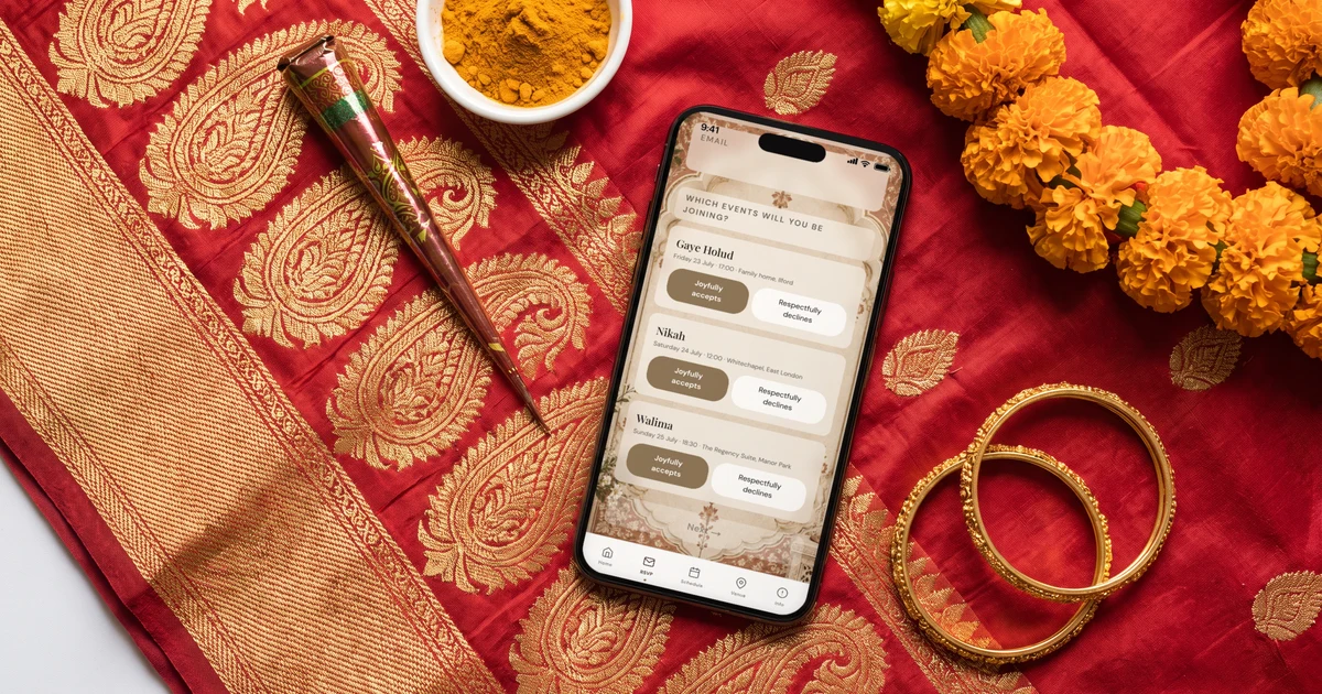 Phone lying flat on a red and gold Benarasi sari showing a Bangladeshi wedding invitation with RSVP for gaye holud, nikah and walima, next to a bowl of turmeric paste, henna cones and marigold garlands
