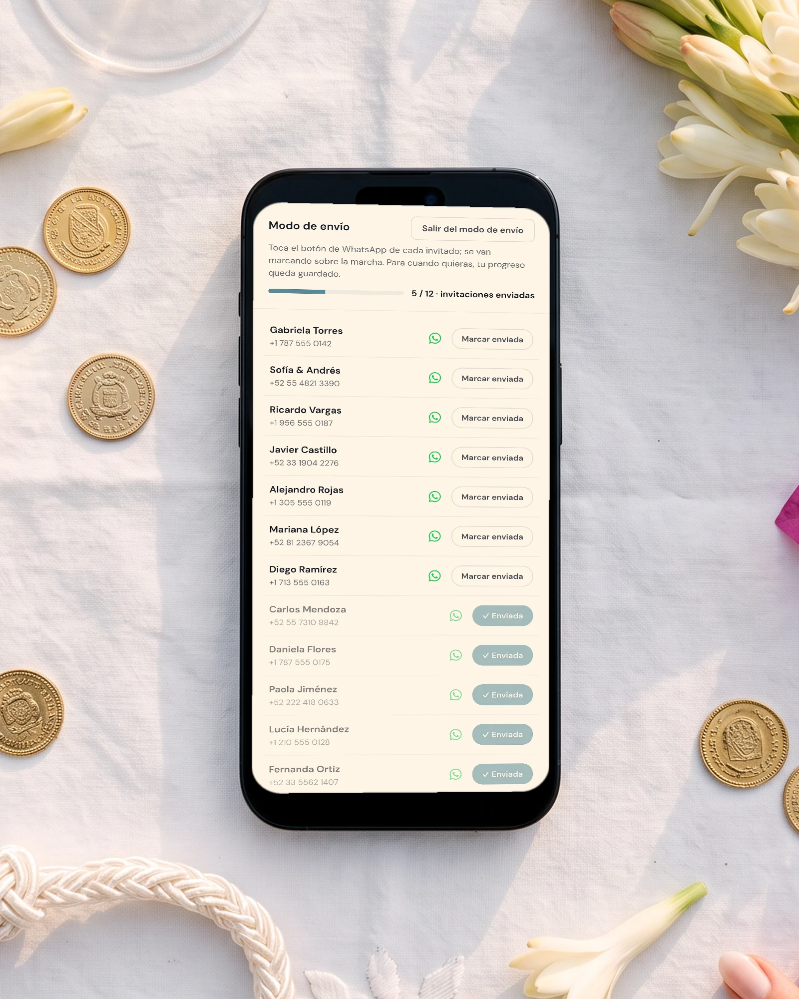 Invitación de boda por WhatsApp: el teléfono muestra el modo de envío con el botón de WhatsApp de cada invitado y la barra de progreso de invitaciones enviadas, entre arras doradas, el lazo de boda y nardos