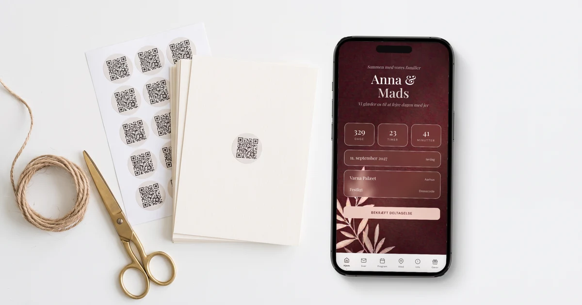 Bryllupsinvitation med QR-kode: trykte invitationskort med et lille rundt QR-klistermærke, et ark med 12 QR-klistermærker og en telefon, der viser invitationens forside, på et lyst skrivebord