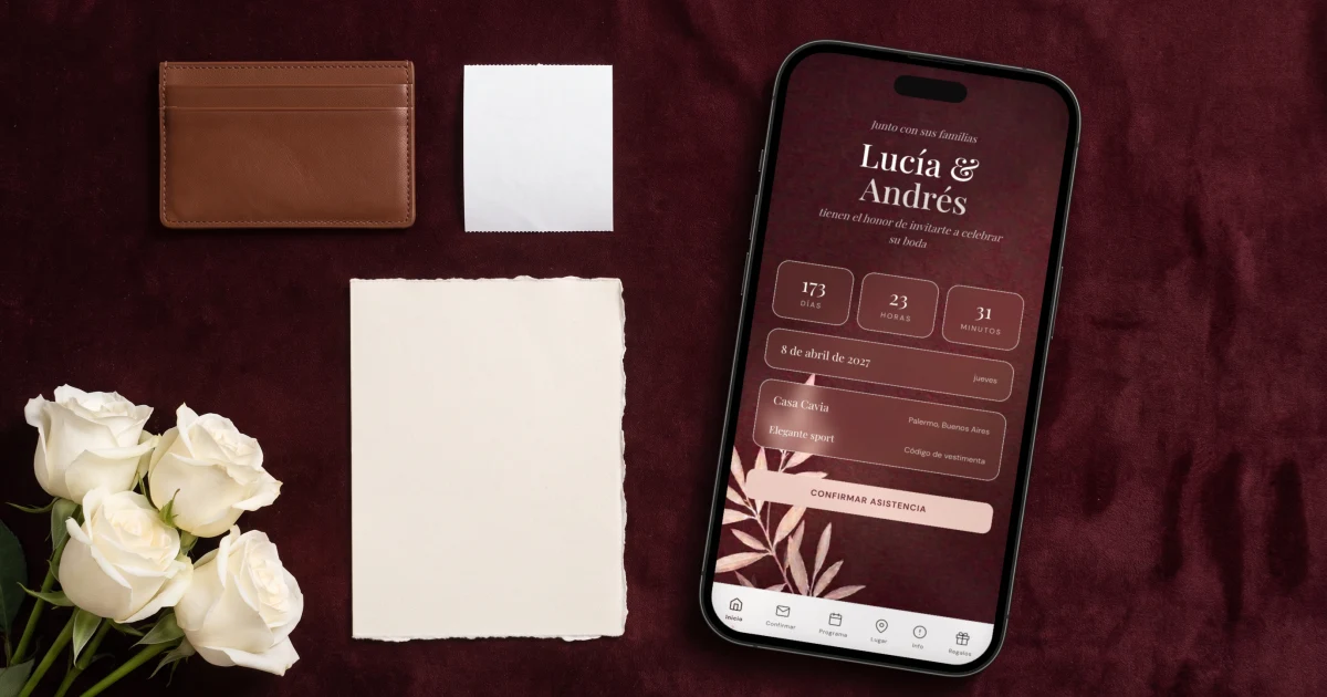 Cuánto cuesta una página web de boda: un teléfono muestra la página de boda en español junto a una cartera y una invitación de papel