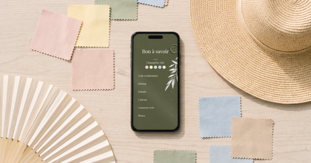 Dress code de mariage en couleur : un téléphone affiche la palette du dress code à côté d'échantillons de tissus et d'une capeline