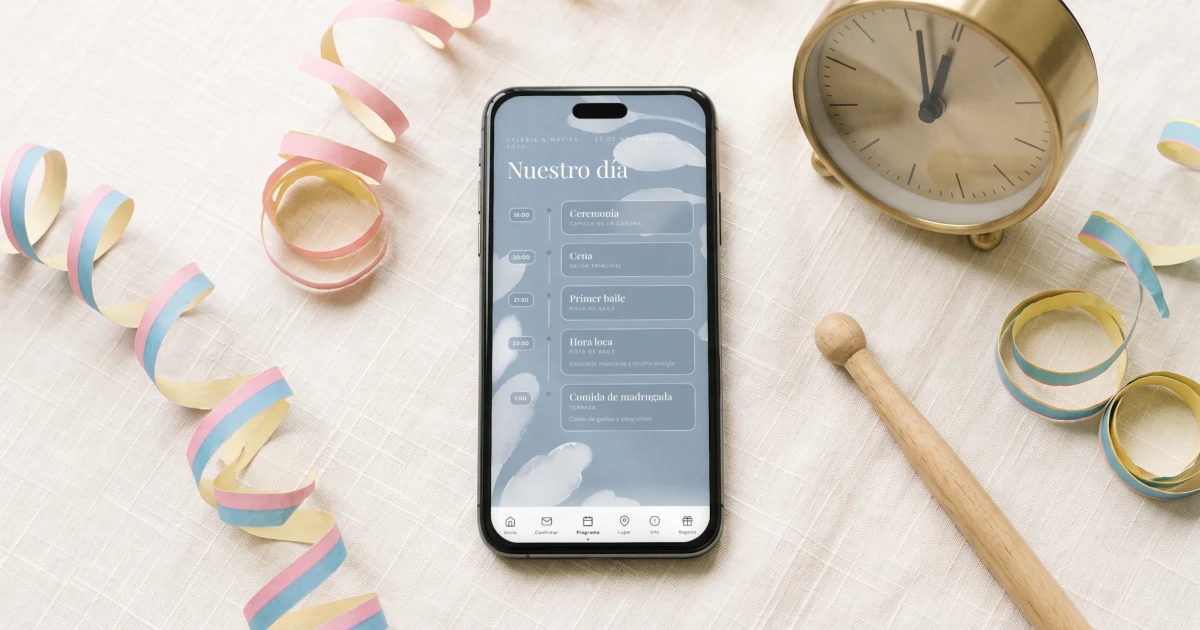 Hora loca en el itinerario del matrimonio: un celular muestra el programa de la invitación con la hora loca a las 23:30, junto a un reloj y serpentinas