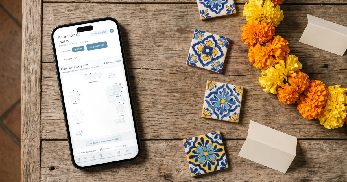 Mejor app de acomodo de mesas: un teléfono muestra el plano de mesas junto a azulejos de talavera, cempasúchil y tarjetas