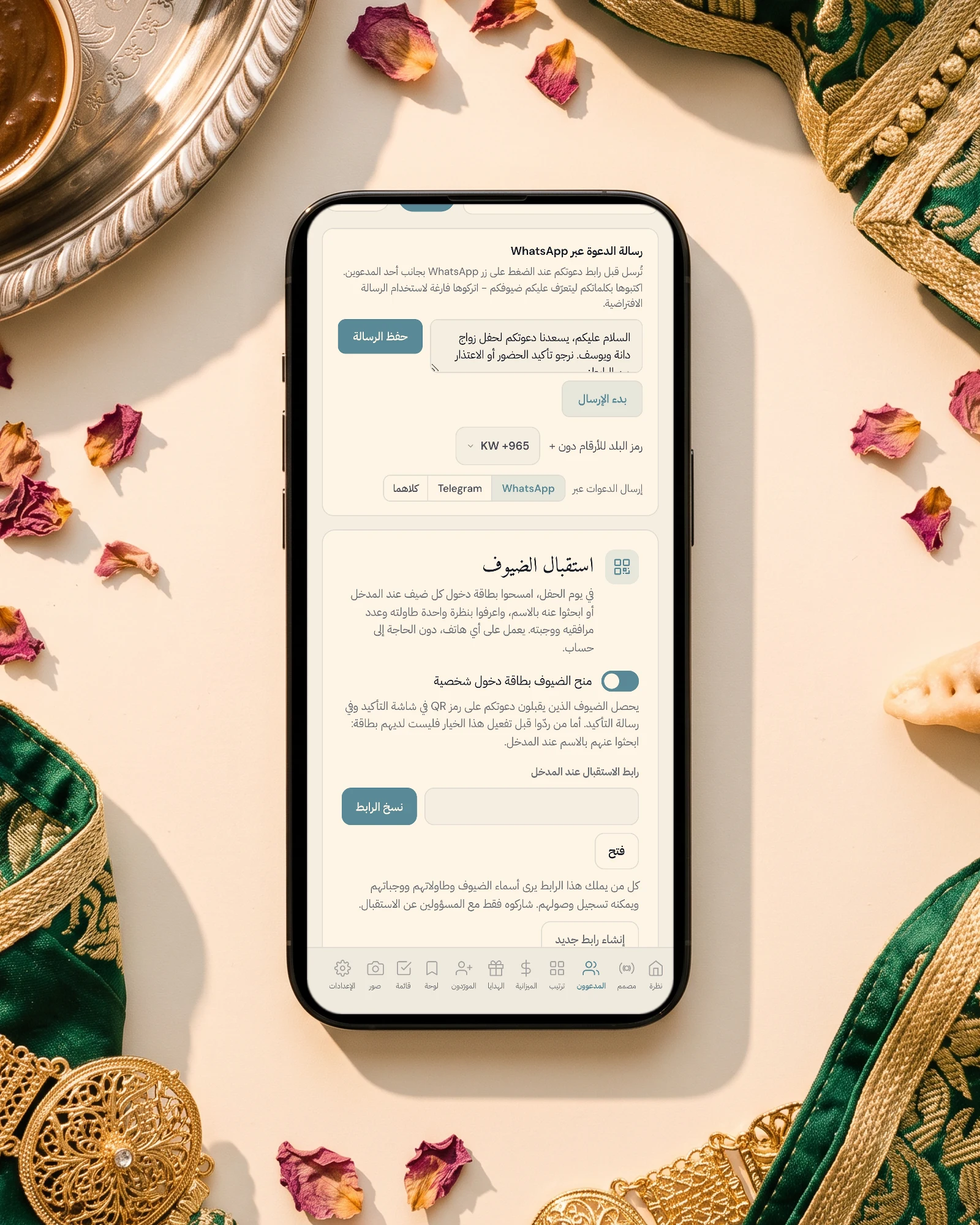 إرسال دعوة العرس المغربي على الواتساب: جوال على قماش القفطان الأخضر والذهبي بجانب صينية الحناء والمضمة الذهبية، يعرض بالعربية رسالة الدعوة على الواتساب واختيار الإرسال بالواتساب أو تيليغرام