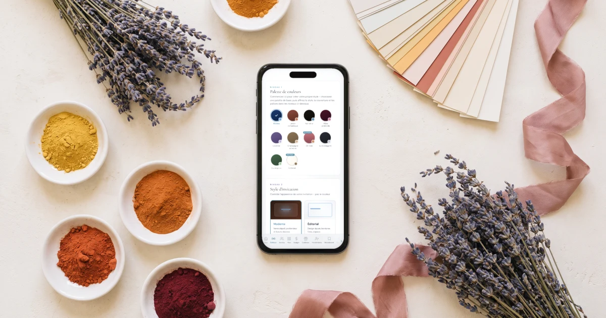 Palette couleur mariage 2026 : un téléphone affiche la palette du faire-part au milieu de lavande, de pigments ocre et d'un nuancier