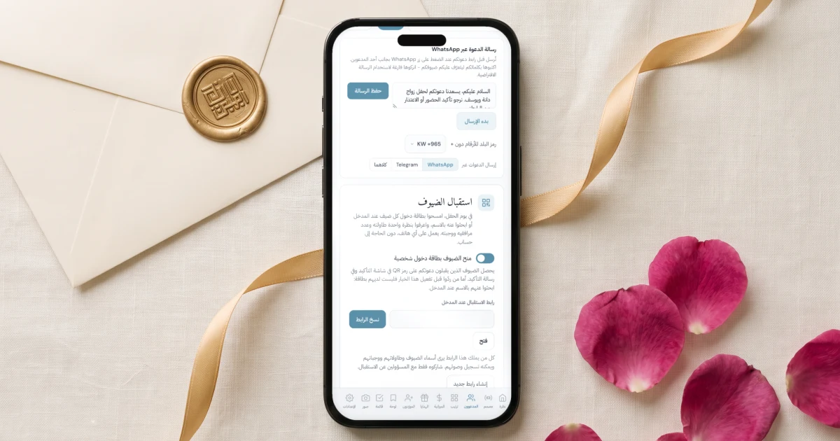 دعوة زفاف إلكترونية مع تأكيد الحضور عبر الواتساب: جوال مسطح يعرض بطاقة رسالة الدعوة عبر الواتساب بنص الرسالة وزر بدء الإرسال، بجانب ظرف كريمي مختوم بالشمع الذهبي وشريط ذهبي وبتلات ورد جوري