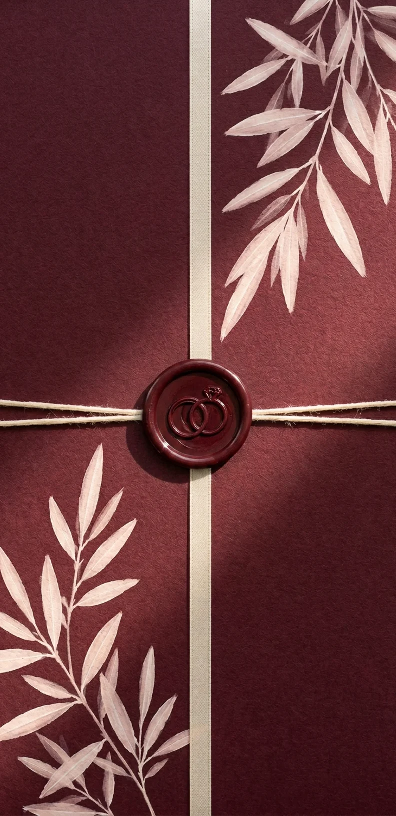 Burgundy wedding invitation with a wax seal beside the digital invitation on a phone